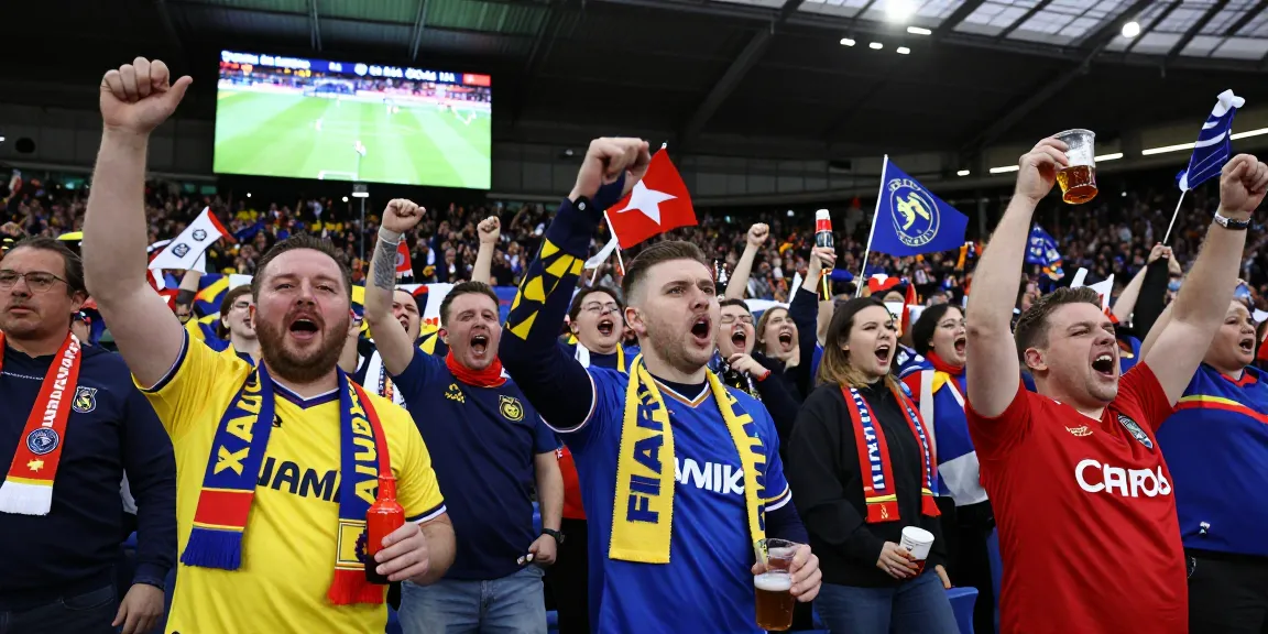 Excited football fans at a Premier League match, bk8 community celebrating their teams.
